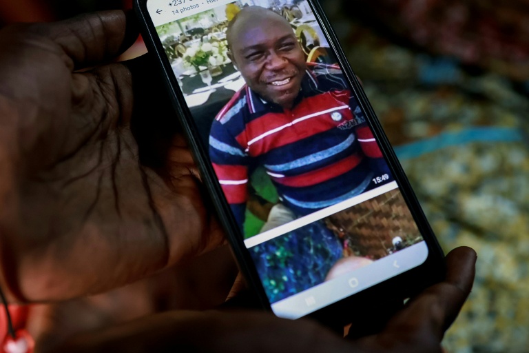 Un membre de la famille montre sur son téléphone portable une photo d'Achille Simo, tué en marge des violences qui secouent le Cameroun depuis la réélection contestée de Paul Biya, le 31 octobre 2025 à Douala 