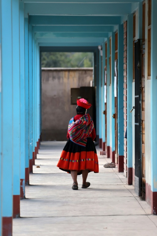Une femme marche dans un bureau de vote lors du second tour de l'élection présidentielle à Ollantaytambo, département de Cusco, au Pérou, le 7 juin 2026