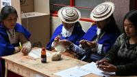 Des femmes misak autochtones font du crochet en attendant les électeurs dans un bureau de vote lors de l'élection présidentielle à la réserve indigène de Guambia, dans le département du Cauca, en Colombie, le 31 mai 2026