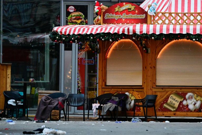 Des chaises vides, des couvertures abandonnées et des débris sur un marché de Noël fermé, où une voiture a foncé dans la foule la veille au soir, le 21 décembre 2024 à Magdebourg, dans l'est de l'Allemagne