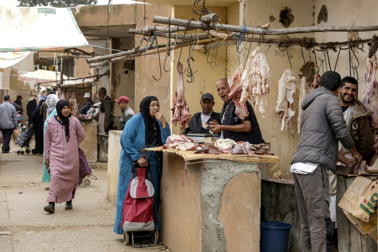 Une Marocaine achète de la viande pendant le marché hebdomadaire à Khemisset, près de Rabat, le 3 juin 2025 