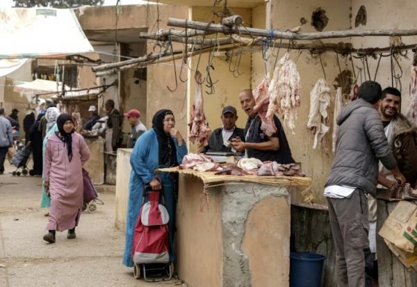 Une Marocaine achète de la viande pendant le marché hebdomadaire à Khemisset, près de Rabat, le 3 juin 2025 