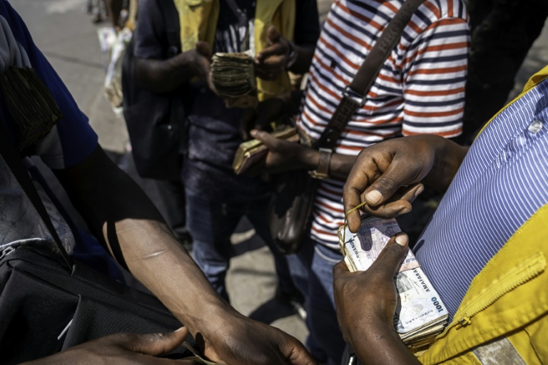 Des billets rwandais et congolais dans les mains de changeurs à Goma, en RDC, le 14 janvier 2026