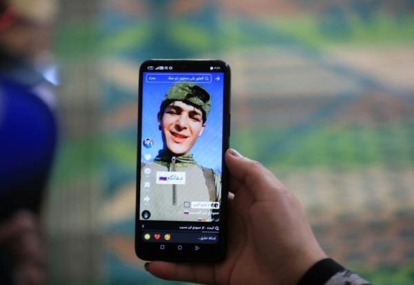 Une photo du jeune Irakien Mohammed Imad, publiée sur les réseaux sociaux après son départ pour se battre dans l'armée russe en Ukraine, visible sur un téléphone portable au domicile familial à Musayab, au sud de Bagdad, le 10 septembre 2025