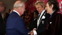 Le chanteur britannique Rod Stewart (c) salue le roi Charles III (g), aux côtés du guitariste britannique Ronnie Wood, à Londres, le 11 mai 2026