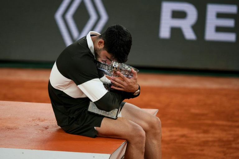 L'Espagnol Carlos Alcaraz enlace le trophée de Roland-Garros après sa victoire en finale sur l'Italien Jannik Sinner, le 8 juin 2025 à Paris