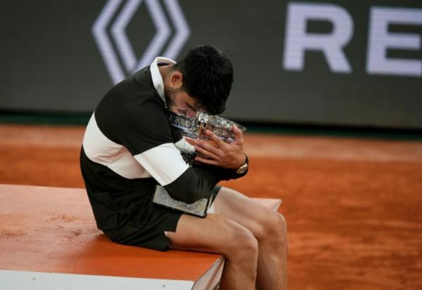 L'Espagnol Carlos Alcaraz enlace le trophée de Roland-Garros après sa victoire en finale sur l'Italien Jannik Sinner, le 8 juin 2025 à Paris
