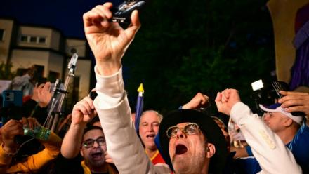 Des partisans du chef du parti AUR George Simion saluent sa victoire au premier tour de la présidentielle, le 4 mai 2025 à Bucarest