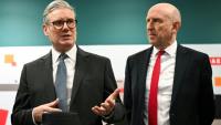 Le Premier ministre britannique Keir Starmer (à gauche) et le secrétaire à la Défense John Healey lors d'une rencontre avec des apprentis de l'entreprise aérospatiale BAE system, à Barrow-in-Furness, dans le nord-ouest de l'Angleterre, le 20 mars 2025