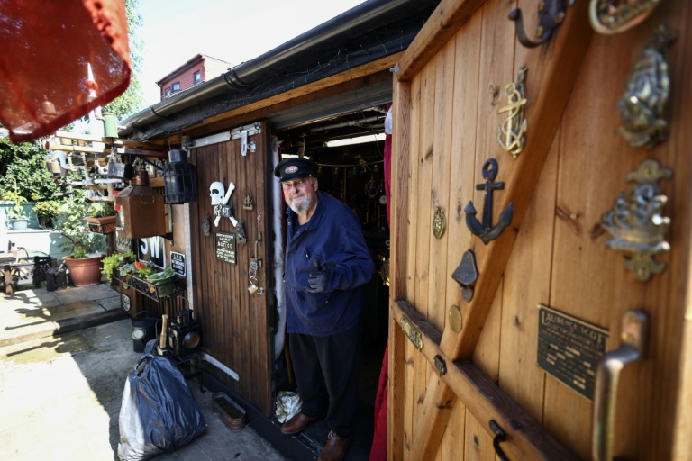 Peter McLaughlin à l'entrée de son abri de jardin, aménagé pour reproduire la chaufferie d'un navire, à l'arrière de sa maison à Londres, le 31 juillet 2026