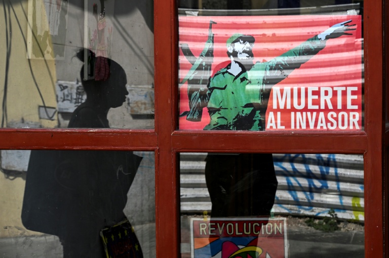 Une femme passe devant une affiche du défunt dirigeant cubain Fidel Castro sur laquelle on peut lire 