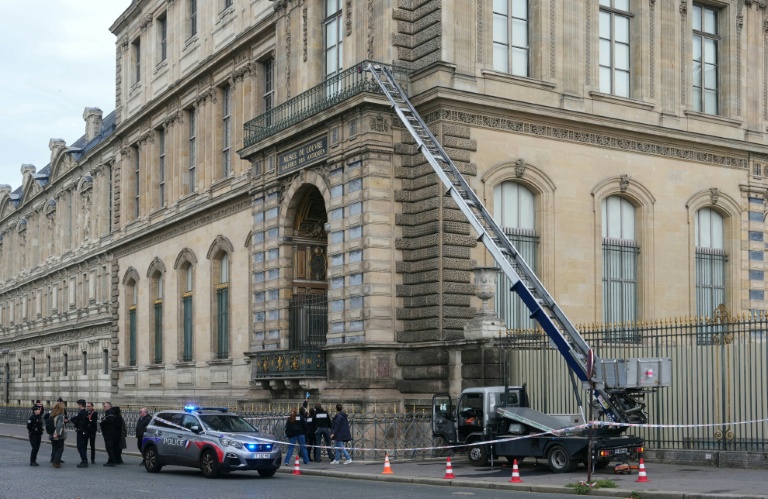 Des policiers près d'un monte-meubles utilisé par des voleurs pour pénétrer dans le musée du Louvre, à Paris, le 19 octobre 2025