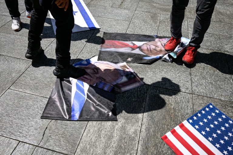 Des manifestants piétinent des photos du président américain Donald Trump et du Premier ministre israélien Benjamin Netanyahu, le 24 juillet 2026 à Caracas