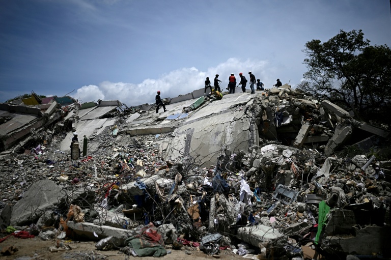 Des sauveteurs et des pompiers dans les décombres d'immeubles effondrés lors du double séisme du 24 juin, à Catia La Mar, dans l'Etat de La Guaira, le 8 juillet 2026 au Venezuela