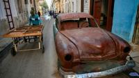 Un homme pousse une charrette près d'une vieille voiture dans une rue de La Havane, le 4 mai 2026