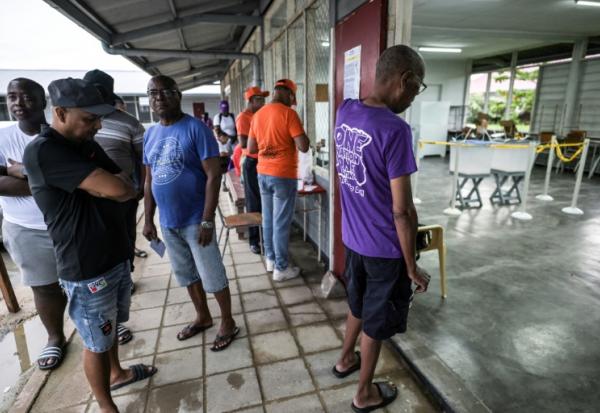 Des électeurs attendent pour voter lors des élections législatives, le 25 mai 2025 à Paramaribo, au Suriname