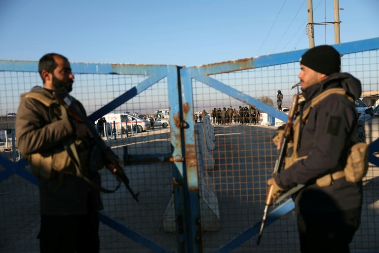 Des membres des forces de sécurité syriennes montent la garde devant l'entrée du camp d'Al-Hol, dans la province de Hassaké,  le 21 janvier 2026