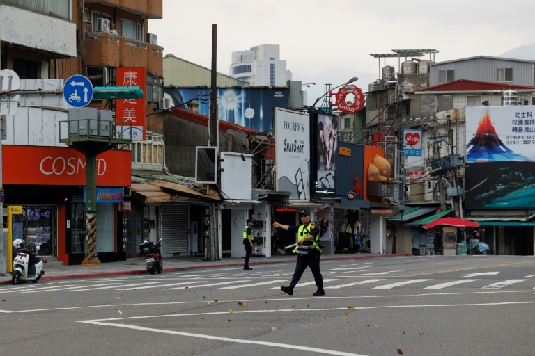 Des policiers dirigent le public vers un abri lors d'une simulation d'attaque à Taipei, le 13 août 2026 sur l'île de Taïwan
