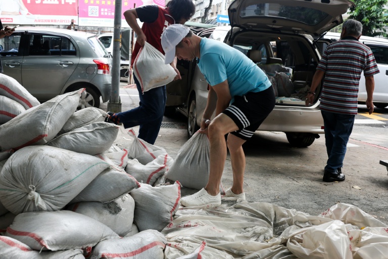 Des habitants installent des sacs de sable pour se protéger du typhon Bavi, le 9 juillet 2026 à Taipei, sur l'île de Taïwan