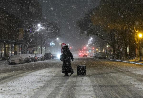 Une personne marche dans les rues enneigées de New York le 22 février 2026, aux Etats-Unis