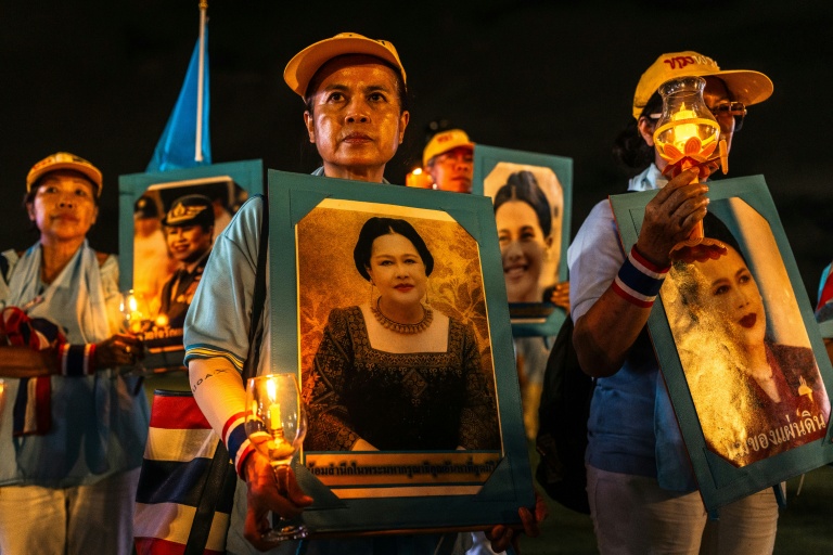 Des partisans de la famille royale tiennent des portraits de la reine mère Sirikit, décédée vendredi, ici le 12 août 2025 à Bangkok