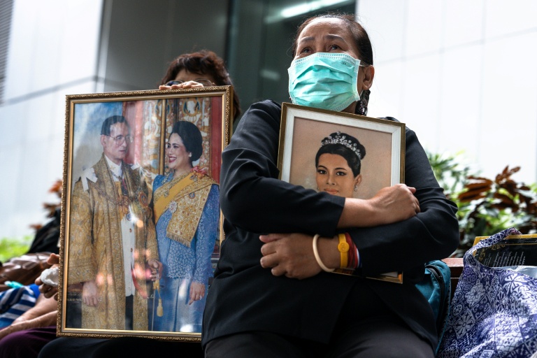 Des Thaïlandaises tiennent un portrait de la reine Sirikit le 25 octobre 2025 devant l'hôpital Chulalongkorn de Bangkok où elle est décédée.