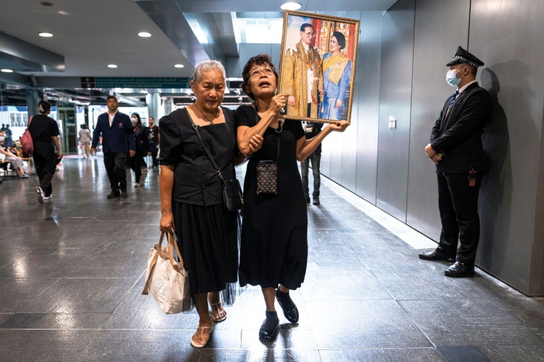 Des Thïlandaises tiennent des portraits de la reine mère Sirikit, le 25 octobre 2025 à l'hôpital Chulalongkorn de Bangkok où elle est décédée.