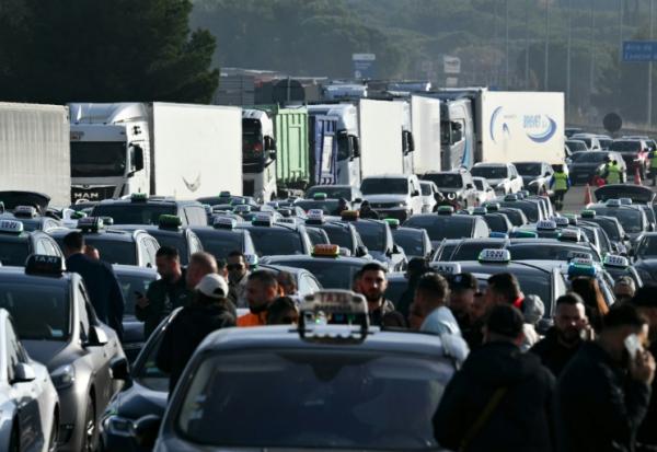 Des taxis bloquent un péage de l'autoroute A7 lors d'une manifestation contre le nouveau système de tarification des transports médicaux à Lançon-Provence (Bouches-du-Rhône) le 2 décembre 2024