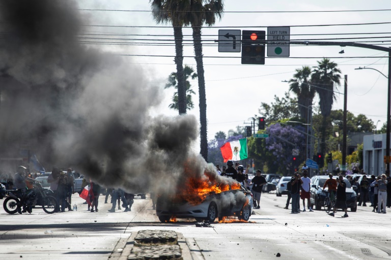 Une voiture en feu lors de manifestations contre les expulsions massives de sans-papiers, le 7 juin 2025 à Los Angeles