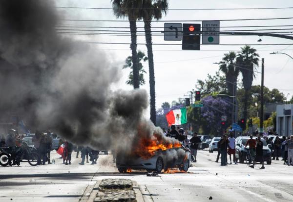 Une voiture en feu lors de manifestations contre les expulsions massives de sans-papiers, le 7 juin 2025 à Los Angeles