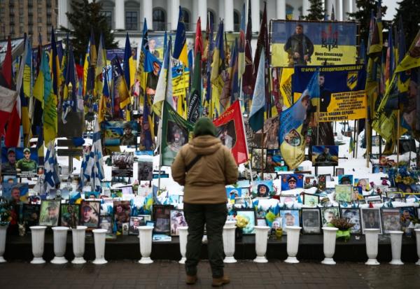 Une personne se tient devant un mémorial de fortune dédié aux soldats ukrainiens et étrangers tombés au combat, sur la place de l’Indépendance à Kiev, le 23 février 2026