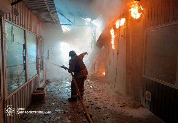 Photo prise et distribuée le 4 avril 2026 par le ministère des situations d'urgence ukrainien montrant des pompiers en train d'éteindre un incendie sur un marché après une frappe à Nikopol, dans le centre-est du pays
