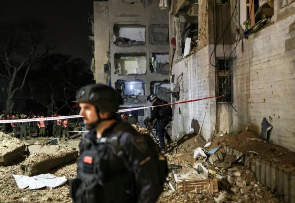Des secouristes inspectent les ruines d'un bâtiment détruit par un missile iranien, le 21 mars 2026 à Arad, dans le sud d'Israël