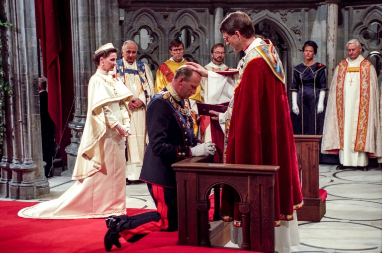 Photo prise le 23 juin 1991 dans la cathédrale de Nidaros, à Oslo, en Norvège, montrant le roi Harald V de Norvège lors de sa prestation de serment par l'évêque Finn Wagle, aux côtés de la reine Sonja (g).