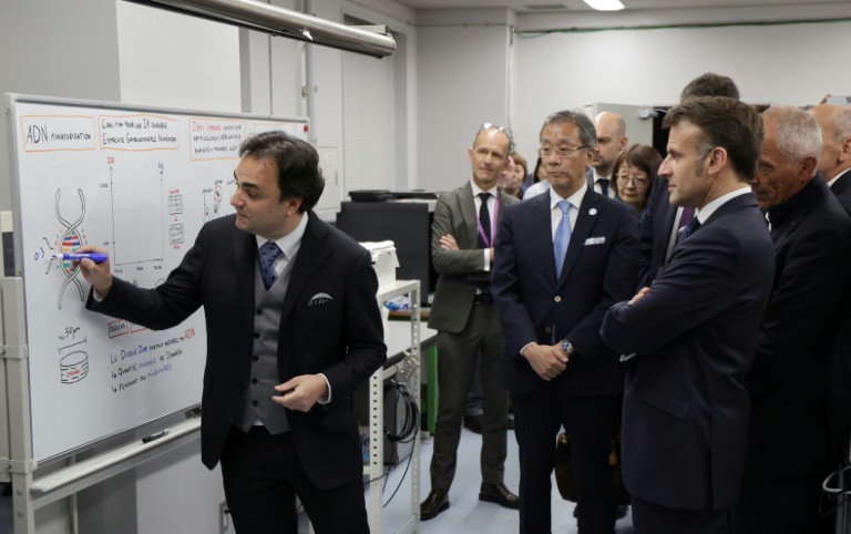 Nicolas Clément (g), directeur du LIMMS, en partenariat avec le Laboratoire international de recherche français CNRS, montre un graphique au président français Emmanuel Macron (à droite) lors de sa visite au laboratoire de Tokyo, le 1er avril 2026