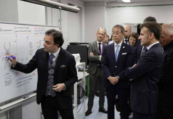 Nicolas Clément (g), directeur du LIMMS, en partenariat avec le Laboratoire international de recherche français CNRS, montre un graphique au président français Emmanuel Macron (à droite) lors de sa visite au laboratoire de Tokyo, le 1er avril 2026