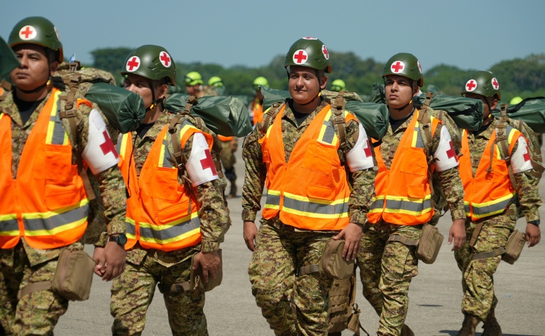 Des membres des forces armées salvadoriennes se préparent à embarquer dans un avion à destination du Venezuela, à la base aérienne de Comalapa, à San Luis Talpa, au Salvador, le 25 juin 2026