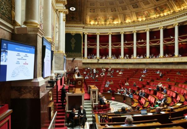 Un écran affiche l'adoption par les députés du premier article de la loi sur la protection de l'enfance et la lutte contre la violence dans les écoles à l'Assemblée nationale, le 1er juin 2026 à Paris