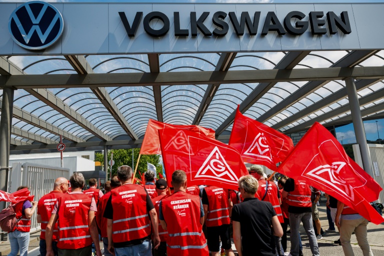 Des salariés de Volkswagen, portant des drapeaux d'IG Metall, protestant contre le plan de restructuration préparé par la direction, à Zwickau, le 9 juillet 2026