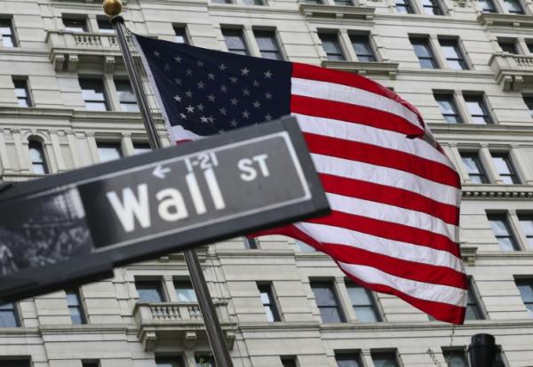 Le drapeau américain flotte derrière un panneau de Wall Street à New York le 22 avril 2026