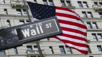 Le drapeau américain flotte derrière un panneau de Wall Street à New York le 22 avril 2026
